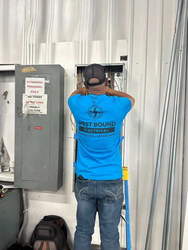 A West Bound Electrical electrician working inside a 480-volt panel on a commercial job